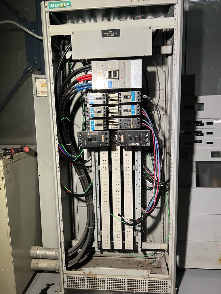 Siemens electrical panel with circuit breakers, wiring, and control modules mounted inside white cabinet