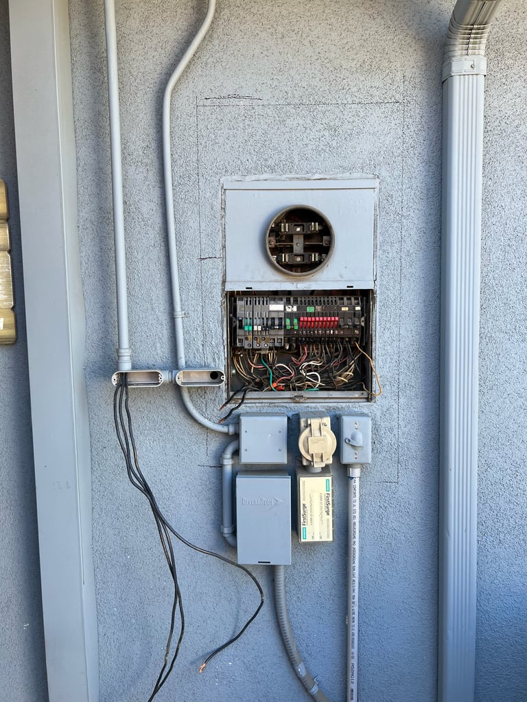 Electrical panel and wiring mounted on concrete wall with cables and circuit breaker components