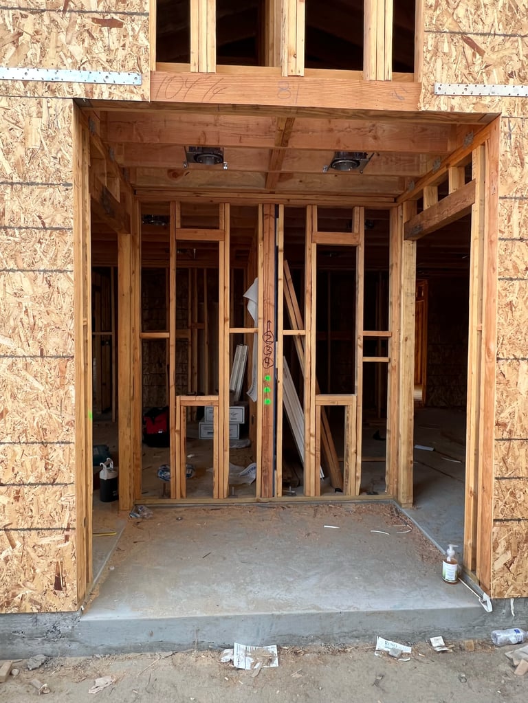 Interior doorway of new home under construction with wooden framing and OSB sheathing surrounding the entrance